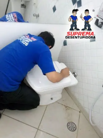 Técnico da Suprema desentupindo vaso sanitário em banheiro residencial