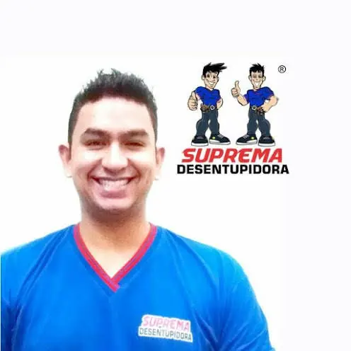 Técnico da Suprema Desentupidora sorrindo, de uniforme azul